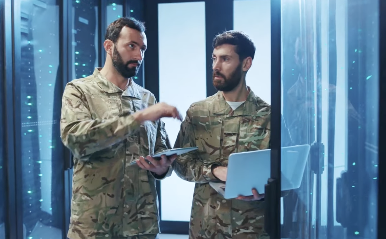 two military men with laptops