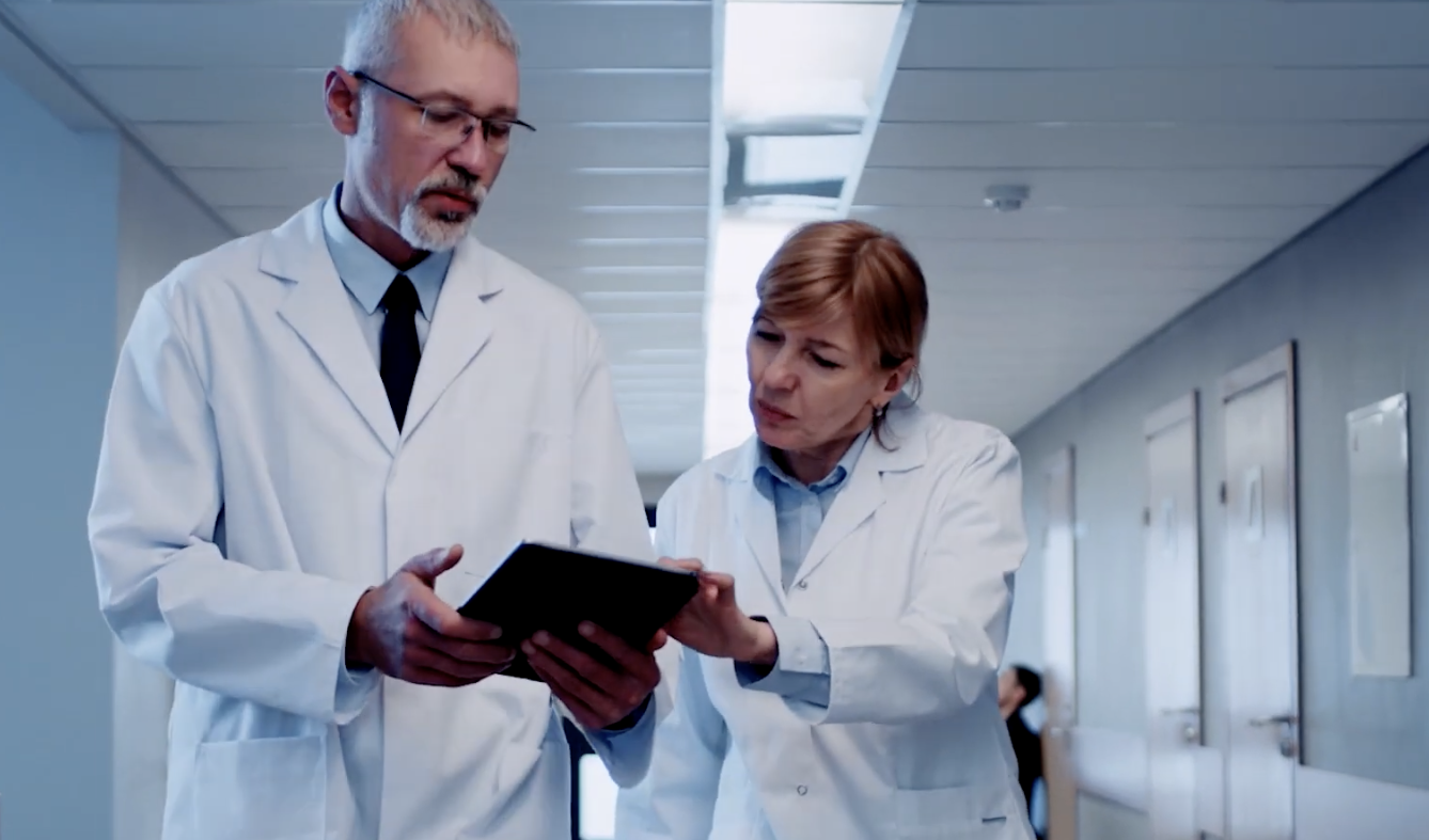 two healthcare workers looking at a tablet